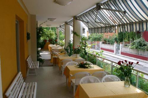セニガッリアにあるHotel Viennaのレストランのテーブルと椅子