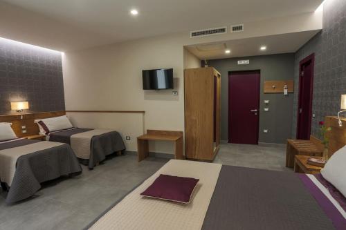 a hotel room with two beds and a tv at La Vigna Hotel in Bonea
