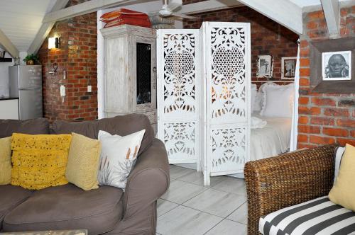 a living room with a couch and a bedroom at Los Olivos at the Yard in Franschhoek