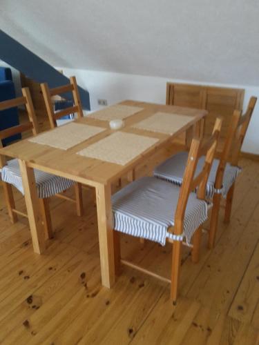 a wooden table with four chairs and a wooden table and chairsktop at Landhotel zur guten Quelle in Eisenach