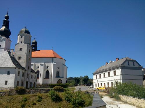 a large white building with a red roof and two buildings at Pension Pošta in Branná