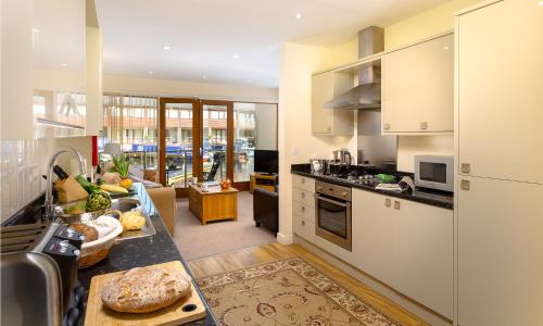 een keuken met witte apparatuur en een woonkamer bij Tewitfield Marina in Carnforth