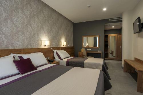 a hotel room with two beds and a mirror at La Vigna Hotel in Bonea