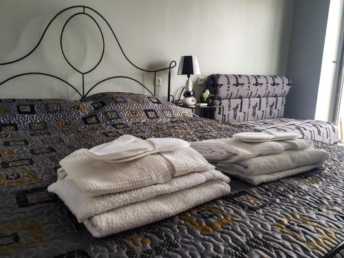 a bed with white towels on it with a bedspread at Hotel T Apartment in Gonio