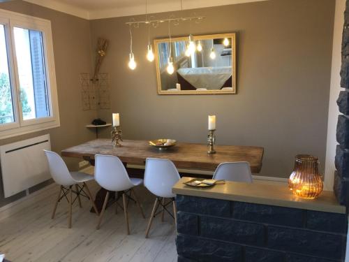 a dining room with a wooden table and white chairs at MONTALIEU SEJOUR 2 Maisons, Les tulipes ou Les Bambous in Montalieu-Vercieu