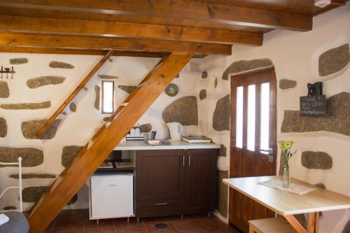 une cuisine avec un escalier en bois dans une maison dans l'établissement CoutoRural, à Vila Nova de Gaia