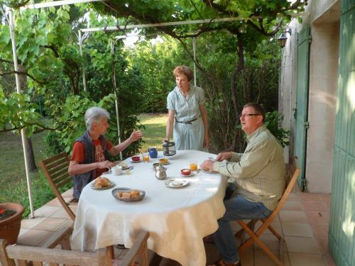 een groep mensen die rond een tafel zitten met eten bij Clos Sainte-Garde in Saint-Didier
