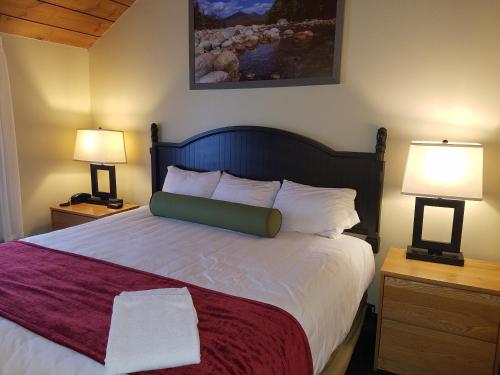 a bedroom with a large bed with two lamps at Village of Loon Mountain, a VRI resort in Lincoln