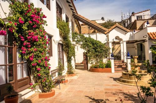 a courtyard with flowers on the side of a building at El Jardin De Su Merced B&B in Sucre