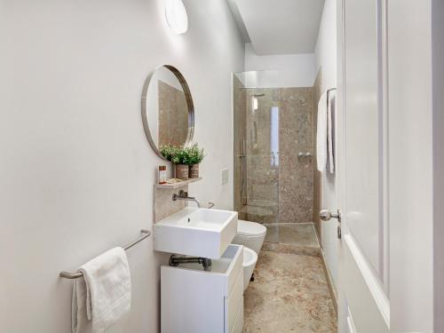 里斯本的住宿－Canaan Lifestyle Apartments Lisbon Combro 77 by Get Your Stay，白色的浴室设有水槽和镜子