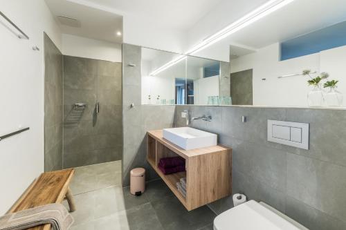 a bathroom with a sink and a toilet at Suites MITTE - Aparthotel in Eisenach