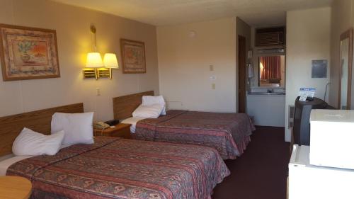 a hotel room with two beds and a kitchen at Cozy Inn in Cortez