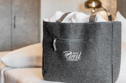 a black bag sitting on top of a bed at SKI - GOLF - WELLNESS Hotel Riml in Hochgurgl