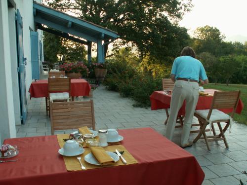 een vrouw staat aan een tafel op een terras bij BIDACHUNA in Saint-Pée-sur-Nivelle