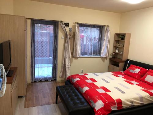 クルジュ・ナポカにあるHaffner Studioのベッドルーム1室(赤と白のキルトのベッド1台付)
