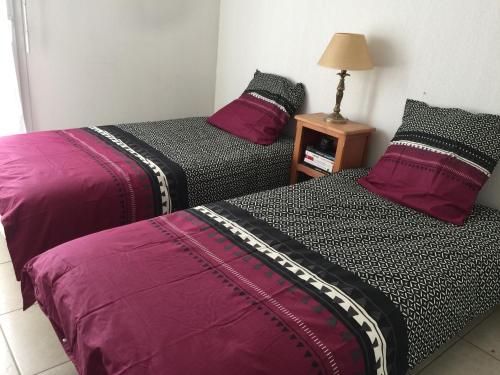 deux lits côte à côte dans une pièce dans l'établissement ROYAL CANNES APPARTEMENT, à Cannes