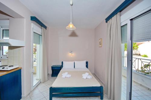 1 dormitorio con 1 cama con toallas en Athanasia Studios, en Patitiri