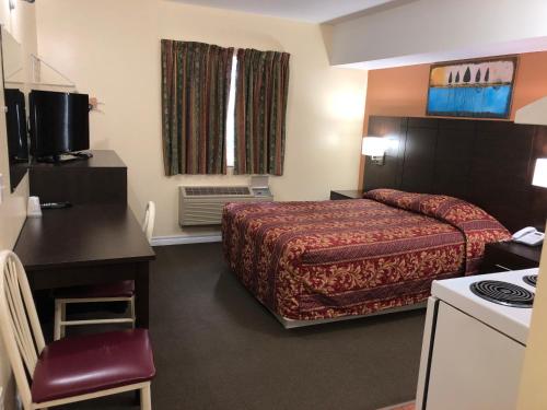 um pequeno quarto de hotel com uma cama e uma cozinha em Royal Windsor Motel em Windsor