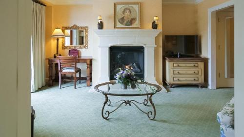 a living room with a fireplace and a table with flowers on it at Delamar Greenwich Harbor in Greenwich