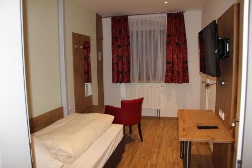 a room with a bed and a table and a chair at Gasthof Zur Post in Schwabhausen bei Dachau