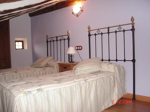 sypialnia z 2 łóżkami z białą pościelą w obiekcie CASA EL AZUD w mieście Gea de Albarracín