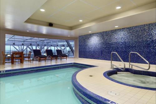 a pool with a hot tub in a hotel room at Fairmont Vancouver Airport In-Terminal Hotel in Richmond