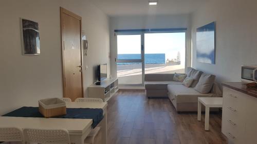 a living room with a couch and a view of the ocean at Casa Playa Ondina in Gáldar
