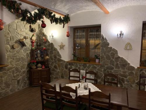 a dining room with a table and a stone wall at Zajazd Zachęta in Kamienna Góra