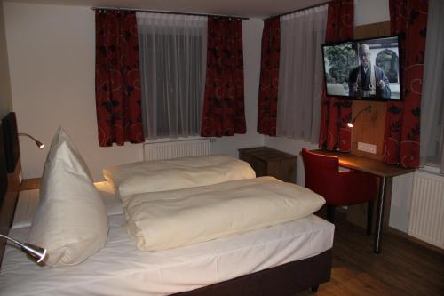 a bedroom with a bed and a television in it at Gasthof Zur Post in Schwabhausen bei Dachau