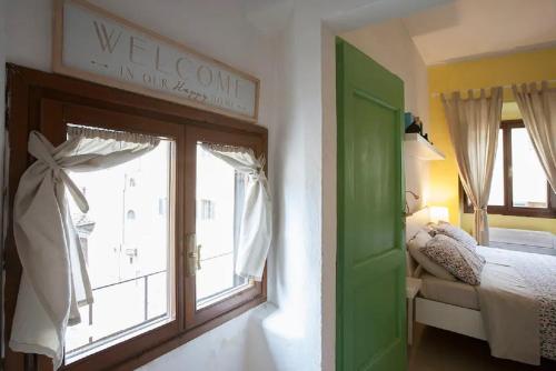 a bedroom with a green door and a window at La casetta dipinta 2.0 in Florence