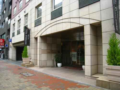 un edificio en una calle con plantas delante en Hotel Villa Fontaine Tokyo-Kayabacho, en Tokio