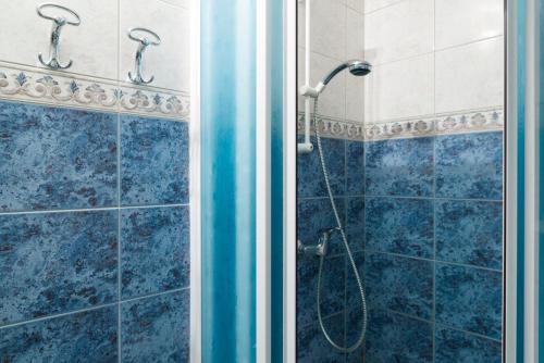a bathroom with a shower with blue tiles at Vila Šiftar in Moravske Toplice