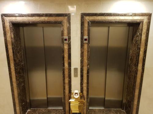 two glass elevators in a bathroom with a fire hydrant at ضيافة بلس شقق مخدومة أقتصادية Dyafah plus 2 in Jeddah
