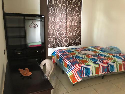 een slaapkamer met een bed, een tafel en een dressoir bij Casa Imelda, Atitlan in Sololá