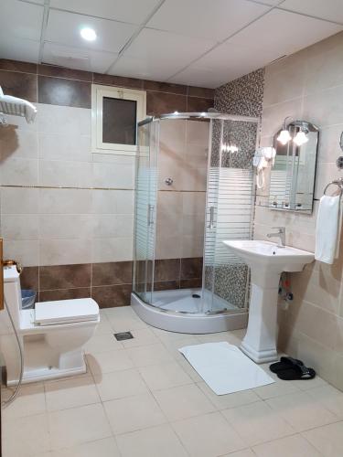 a bathroom with a shower and a toilet and a sink at ضيافة بلس شقق مخدومة أقتصادية Dyafah plus 2 in Jeddah