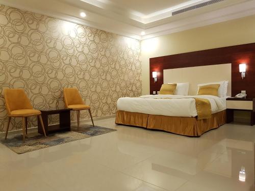 um quarto com uma cama grande e 2 cadeiras em Farha International 2 Residential Units em Jidá