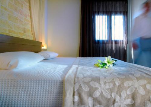 a bedroom with a bed with a flower on it at Minos Village in Agia Marina Nea Kydonias