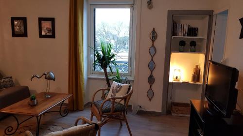 een woonkamer met een bank en een raam bij " LA BIENVENUE " in Ploemeur