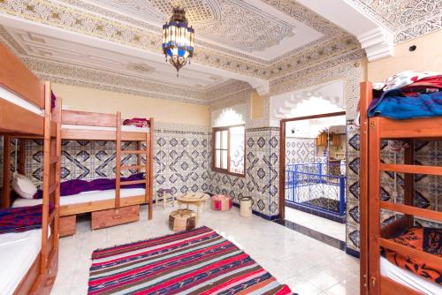 a room with bunk beds and a chandelier at Mosaic Hostel in Marrakesh