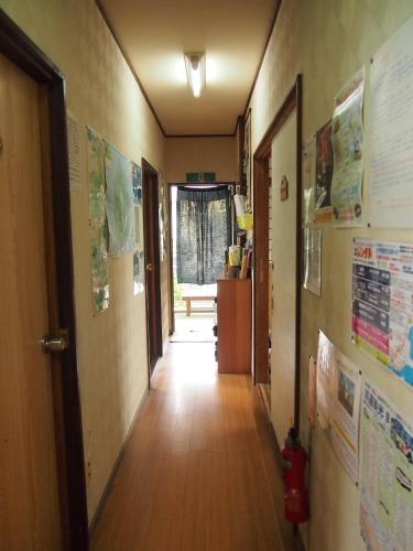 a hallway with posters on the walls of a room at Minshuku Iwakawa in Yakushima
