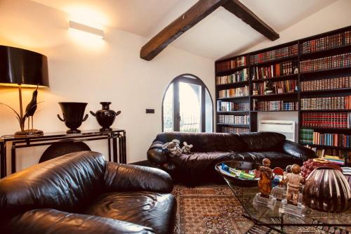una sala de estar con muebles de cuero y estanterías en Borgo Antico XIX sec., en Gesturi