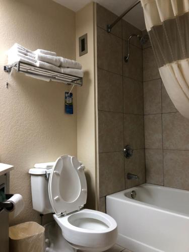 y baño con aseo blanco y ducha. en Baymont by Wyndham Cincinnati Sharonville, en Sharonville