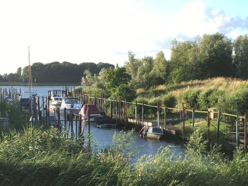 a group of boats are docked in a river at COSY & NATURAL *FIREPLACE*GARDEN*2 BIKES in Heinenoord