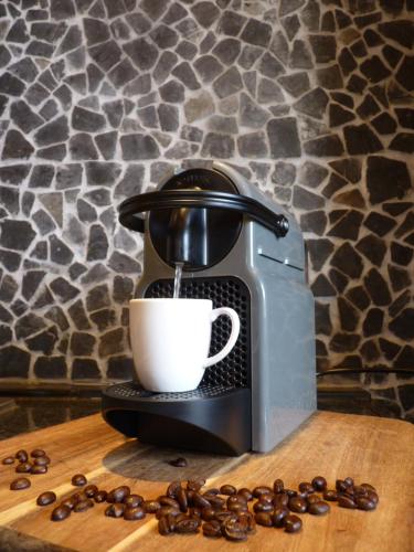 a coffee machine sitting on a wooden table with a cup at COSY & NATURAL *FIREPLACE*GARDEN*2 BIKES in Heinenoord