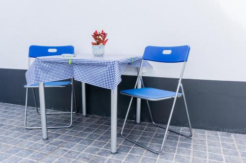a table with two chairs and a table with a plant at Casa da Tia Adília (AL) in Ponta Delgada