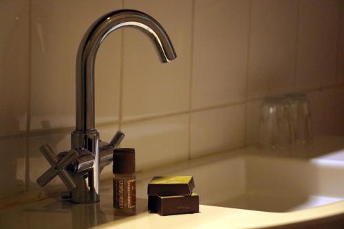 a sink with a faucet and a bar of soap at Hotel Museo El Greco Puerto Varas in Puerto Varas