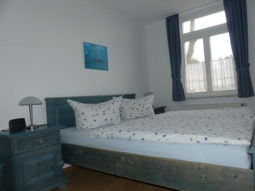 um quarto com uma cama grande e uma janela em Landhaus am Haff em Stolpe auf Usedom