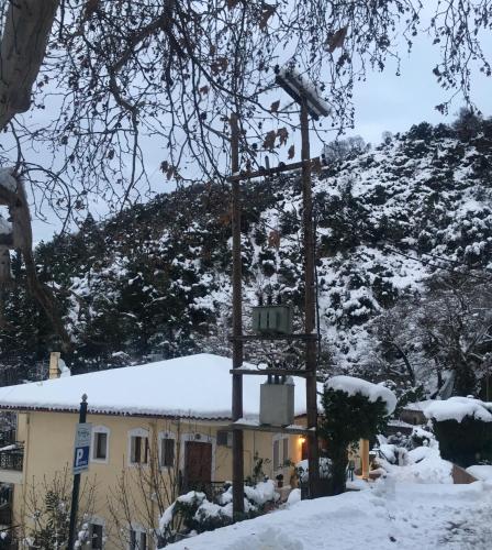 a building in the snow with a street light at Archontiko tou Ziaka in Ipáti