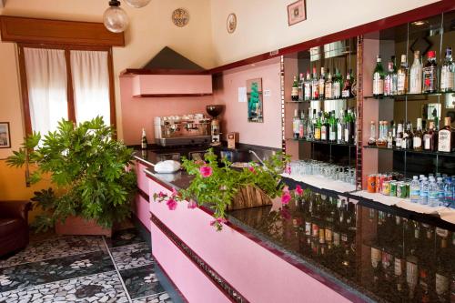 a bar in a restaurant with a pink counter at Hotel Adriatico in Borgo Fosso Ghiaia