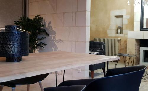 une table dans une pièce avec des chaises et une plante dans l'établissement NATURE & CHATEAUX, à Azay-le-Rideau